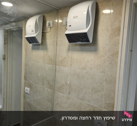מייבש ידיים מותקן על קיר אריחים בחדר אמבטיה